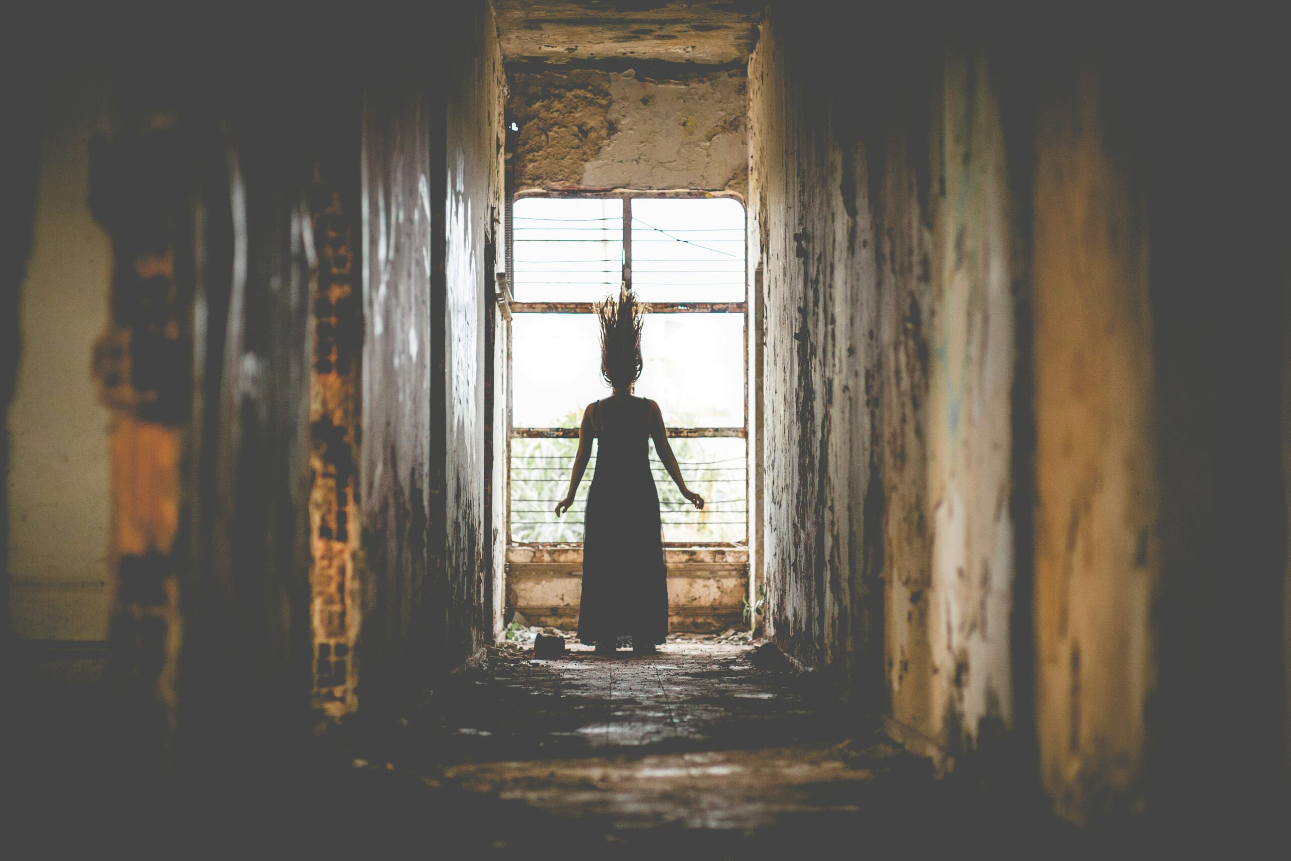 woman in window of creepy house